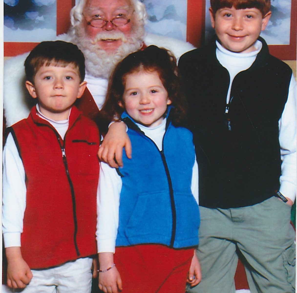 three-adorable-little kids-with-santa-smile-at-camera