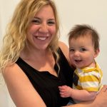 mom-holds-small-baby-and-smiles-at-camera