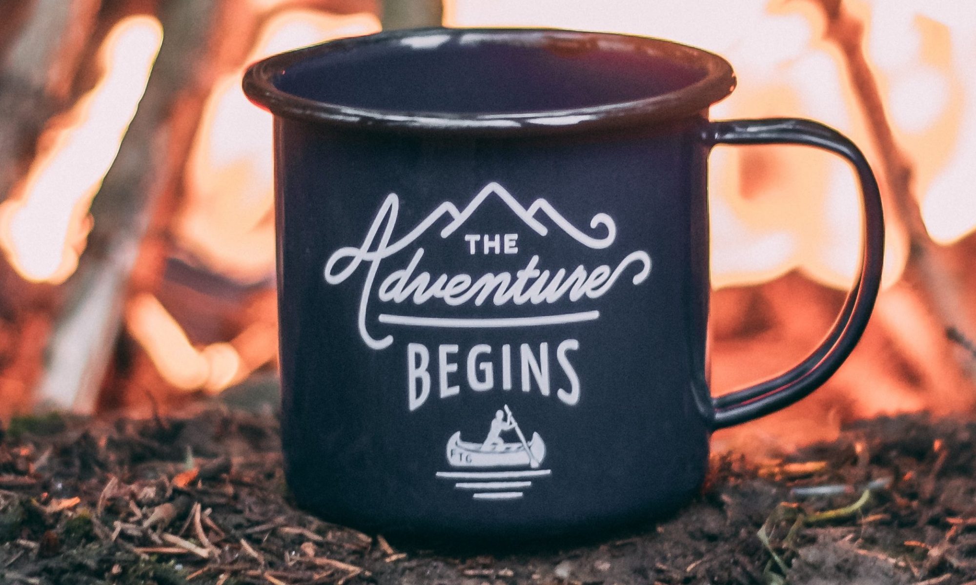 campfire-behind-tin-cup-with-the-adventure-begins-text-and-canoe-icon-by-ole-witt-on-unsplash