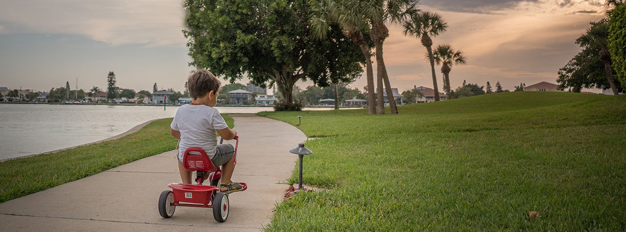 little-boy-rides-red-tryicycle-by-water-image-by-karo-kujanpaa-on-unsplash