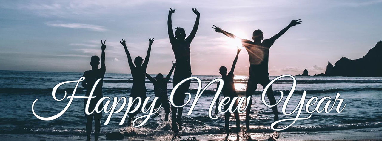 Text says 'Happy New Year.' Group, backlit by sunrise, jumps for joy on beach. Image by Bayu Jefri on Pexels.