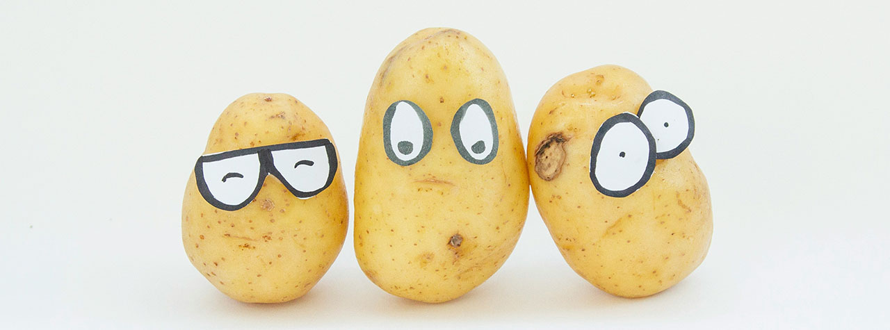 Three golden potatoes have comic faces with the addition of expressive & funny stickers giving them eyes. Image by Franco Antonio Giovanella on Unsplash.