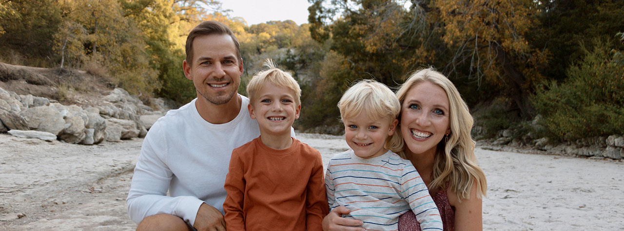 Family photo of post author with her two small boys and husband in beautiful outdoor setting. Image courtesy of @foodallergiesotg