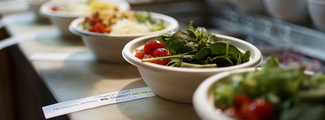 Custom green salads are lined-up next to each other for pick-up by customers. Image by Brian J. Tromp on Unsplash.