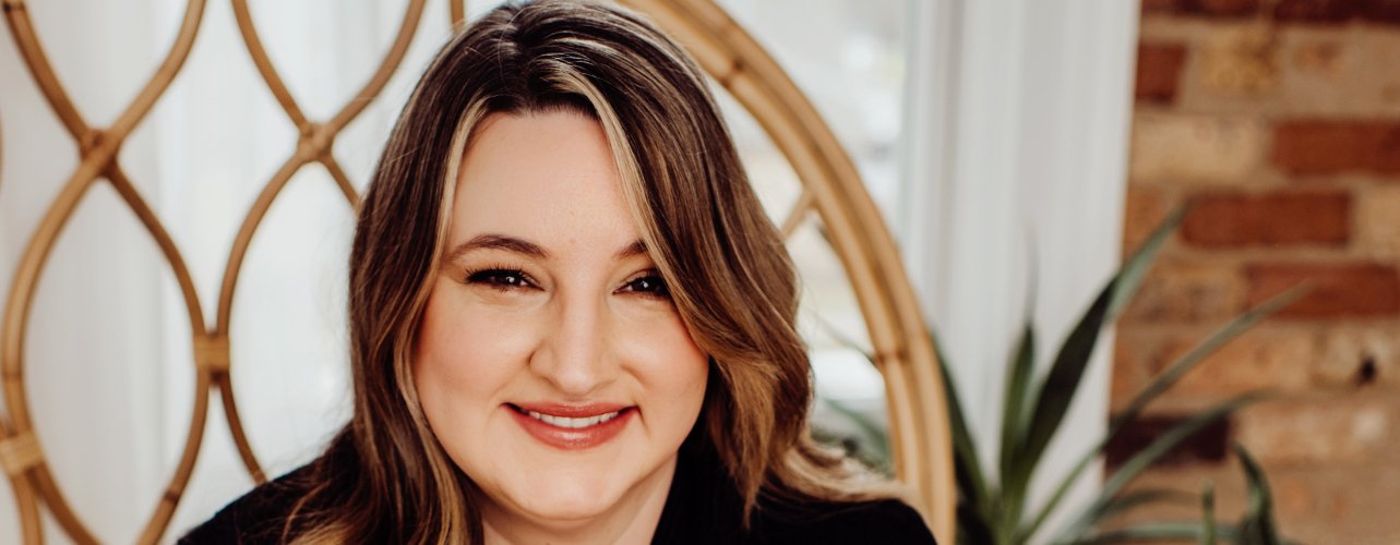 Close-up of Tamara Hubbard, The Food Allergy Counselor. Pretty brown haired woman with green eyes sits in high backed chair and smiles.