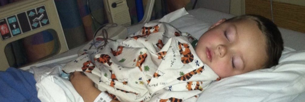 Small child in a hospital gown sleeps in a hospital bed. Image courtesy of Fallon Schultz and iFPIES.