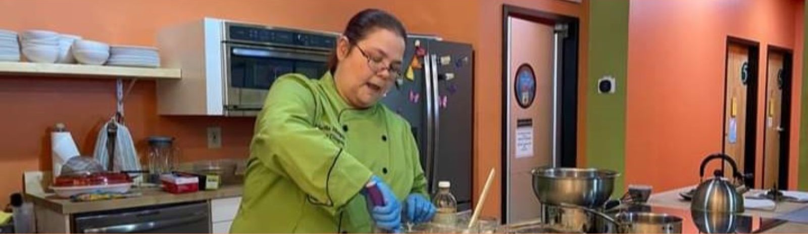 Chef Martha Morgan (aka Allergy Dragon) demonstrates making no-bake celiac and allergy-friendly cookies while teaching a cooking class at Rainbow Market in Louisville, Kentucky. Image courtesy of Allergy Dragon.