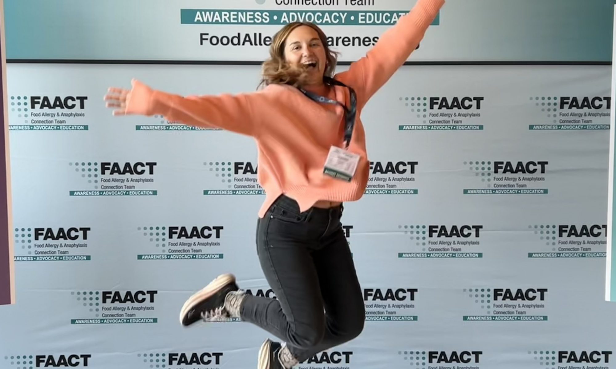 Invisibly Allergic Founder and Author Zoe Slaughter jumps for joy at a FAACT influencer conference. Image courtesy of Invisibly Allergic.